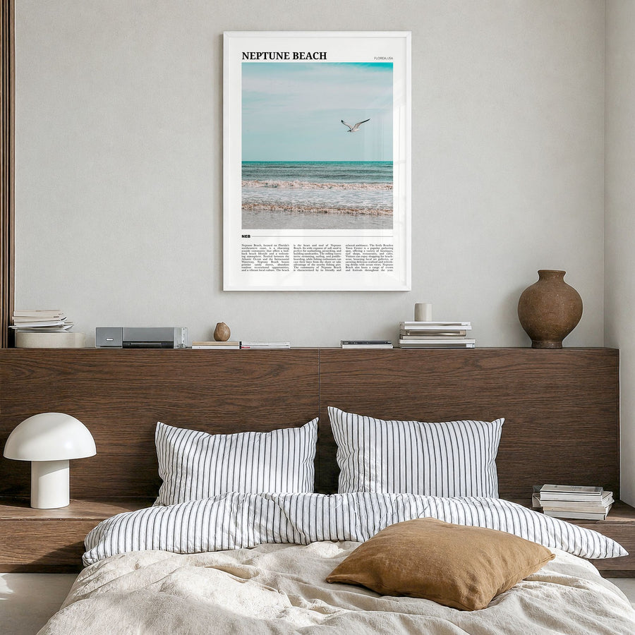 Neptune Beach Travel Poster in a white wood frame, hanging in a bedroom