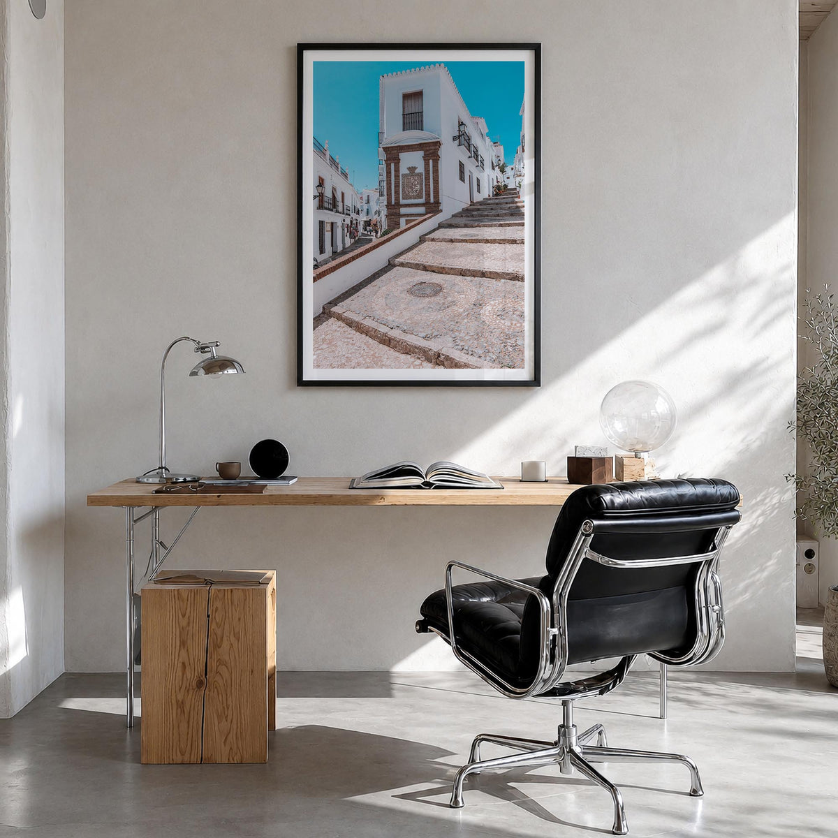 Nerja colorful photo poster of Spain – vertical wall art in black wood frame with white border, hanging on wall