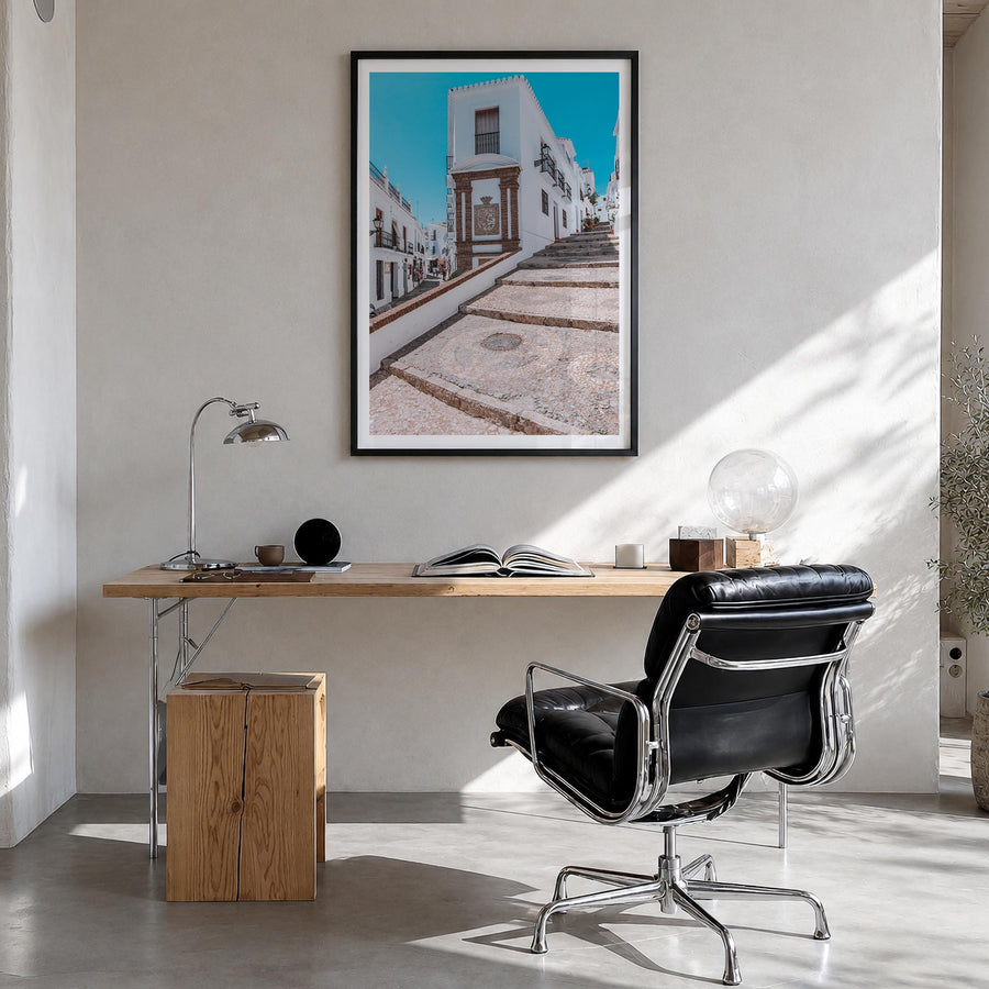 Nerja colorful photo poster of Spain – vertical wall art in black wood frame with white border, hanging on wall