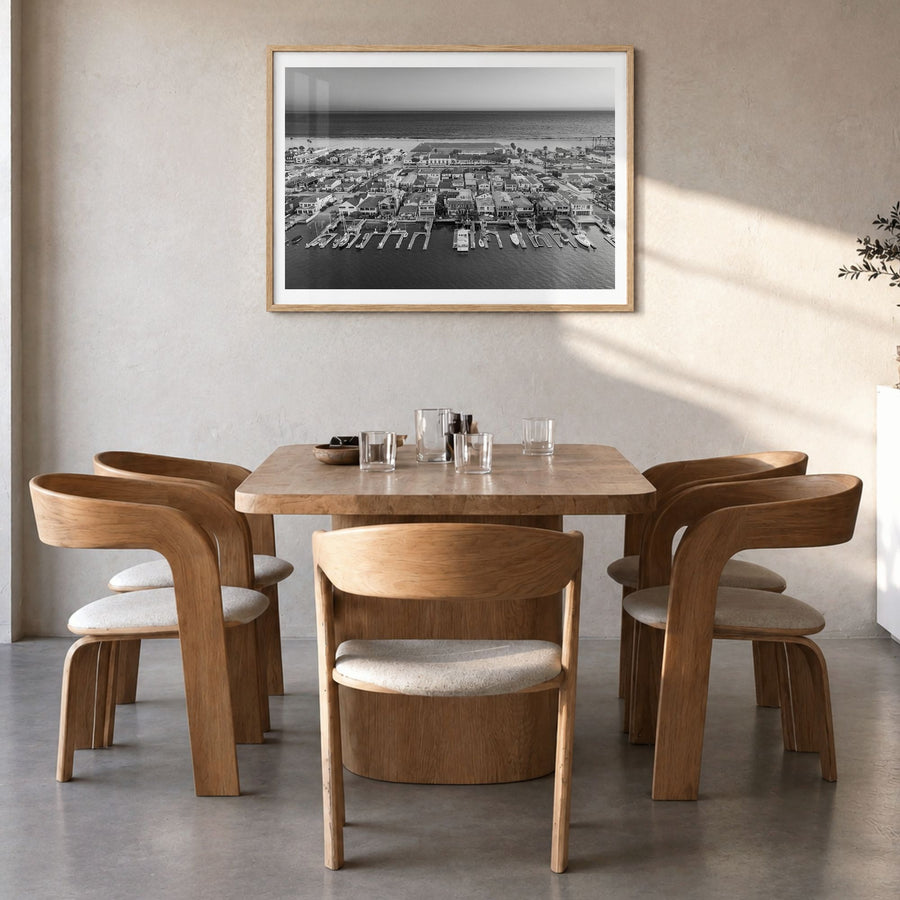 Newport Beach Photo Poster in a natural wood frame, hanging in a dining room, white border