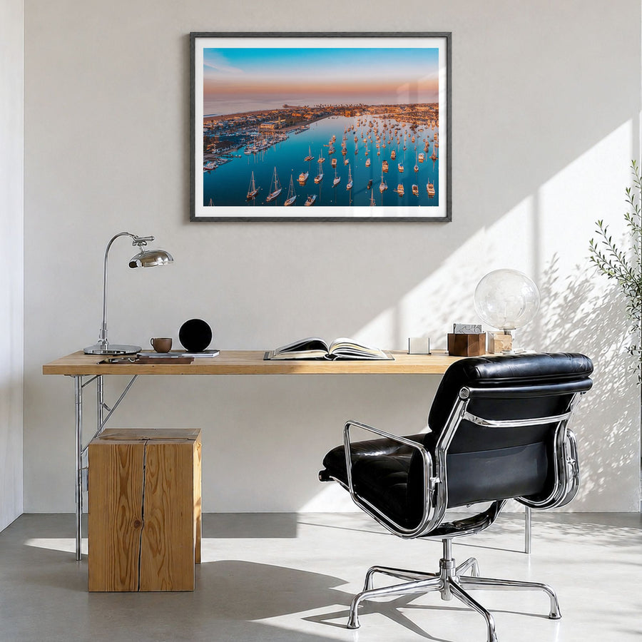 Newport Beach Photo Poster in a black wood frame, hanging in a bright home office, white border