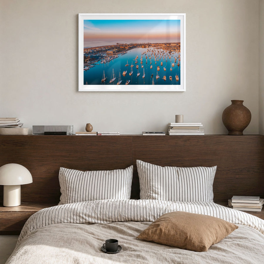 Newport Beach Photo Poster in a white wood frame, hanging in a bedroom, white border