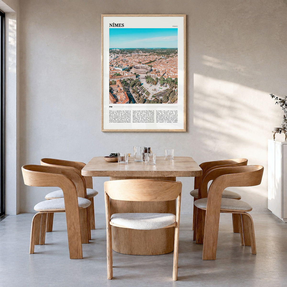 Nîmes Travel Poster in a natural wood frame, hanging in a dining room
