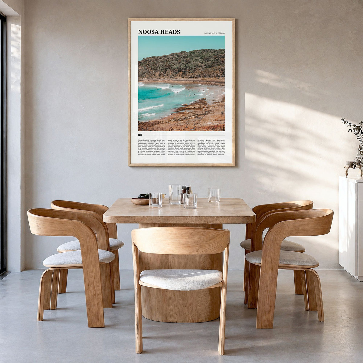 Noosa Heads Travel Poster in a natural wood frame, hanging in a dining room