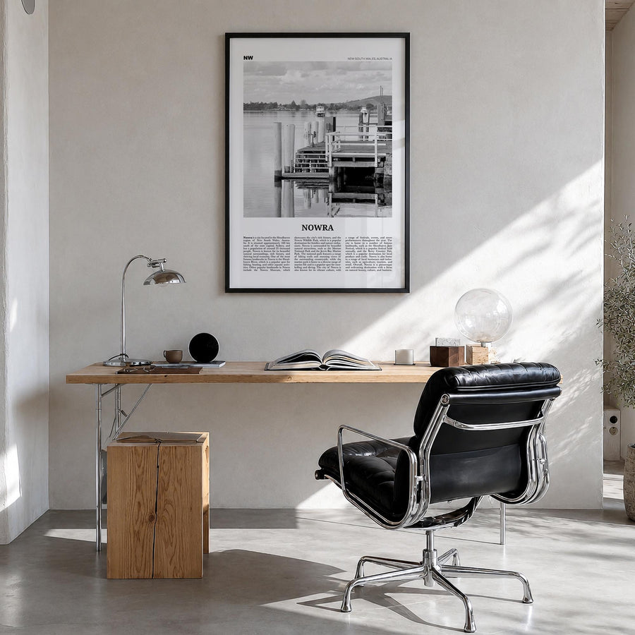 Nowra black & white newspaper poster of Australia – vertical wall art in black wood frame, hanging on wall