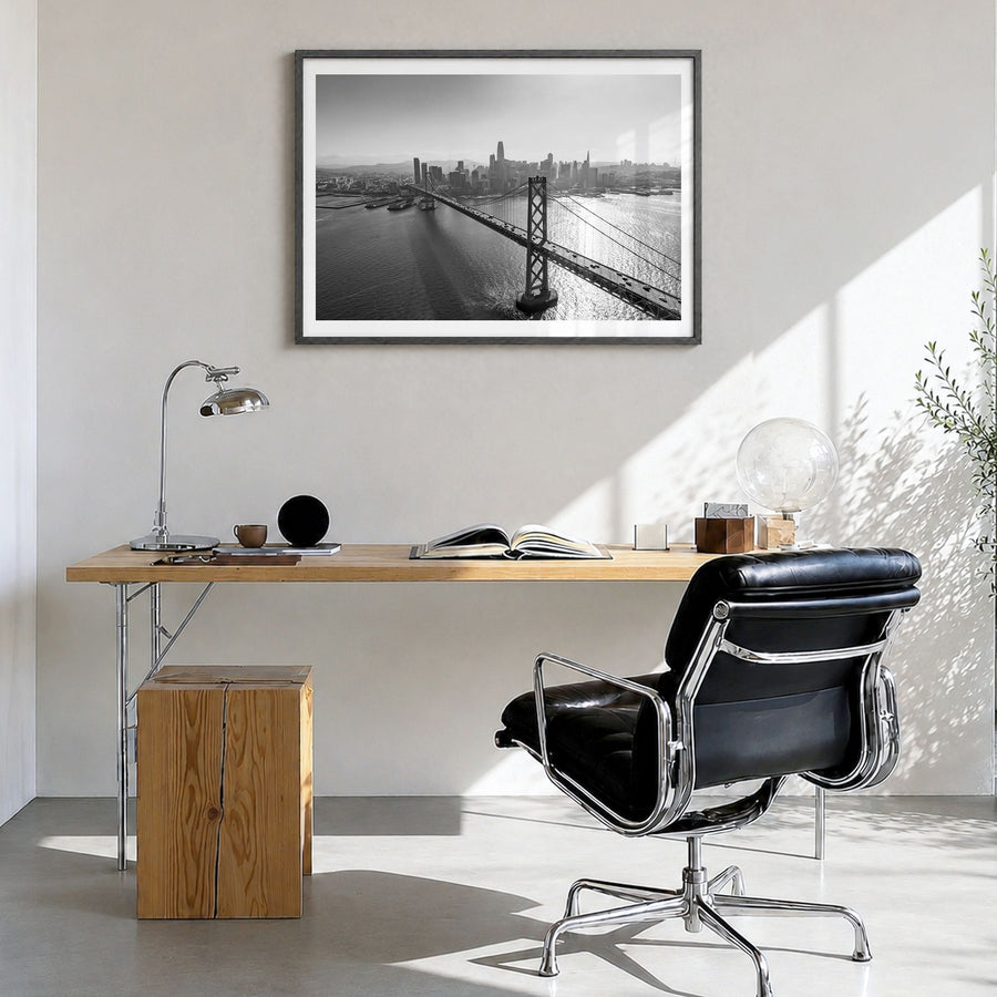 Oakland Photo Poster in a black wood frame, hanging in a bright home office, white border
