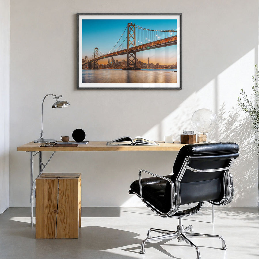 Oakland Photo Poster in a black wood frame, hanging in a bright home office, white border