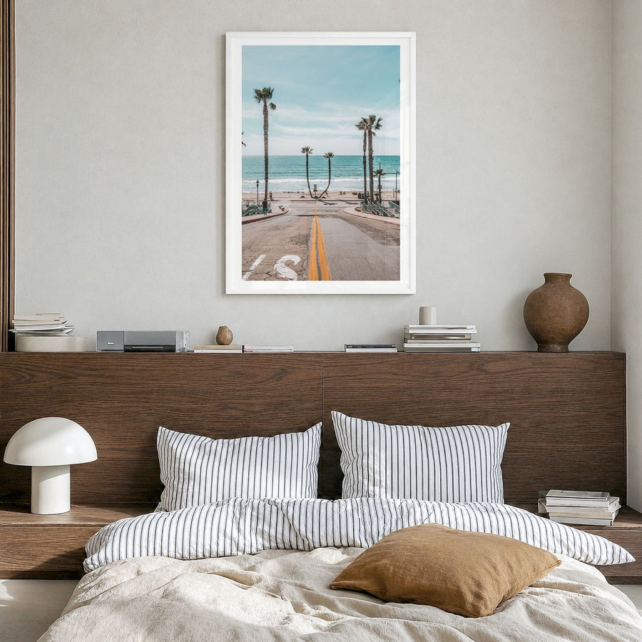 Oceanside Photo No 2 Poster in a white wood frame, hanging in a bedroom, white border
