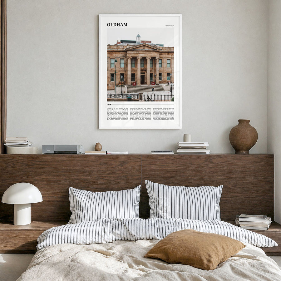 Oldham Travel Poster in a white wood frame, hanging in a bedroom