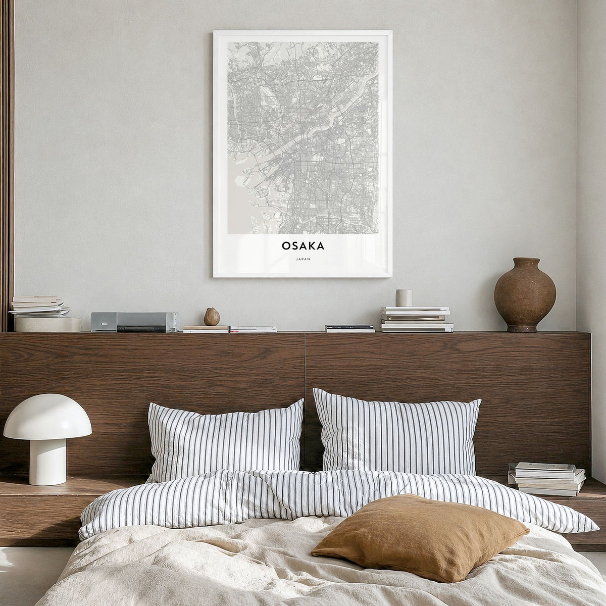 Osaka Map Poster in a white wood frame, hanging in a bedroom