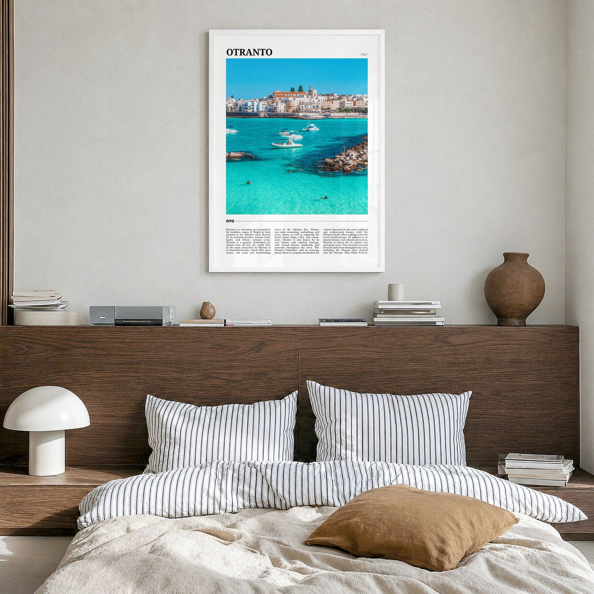 Otranto Travel Poster in a white wood frame, hanging in a bedroom