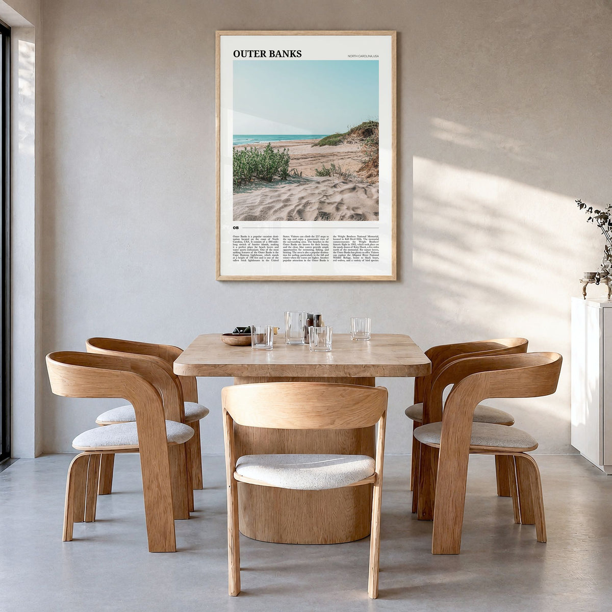 Outer Banks Travel Poster in a natural wood frame, hanging in a dining room