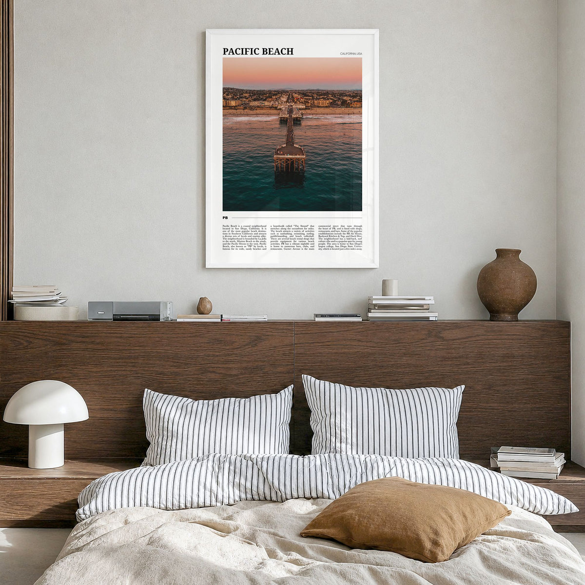 Pacific Beach Travel Poster in a white wood frame, hanging in a bedroom