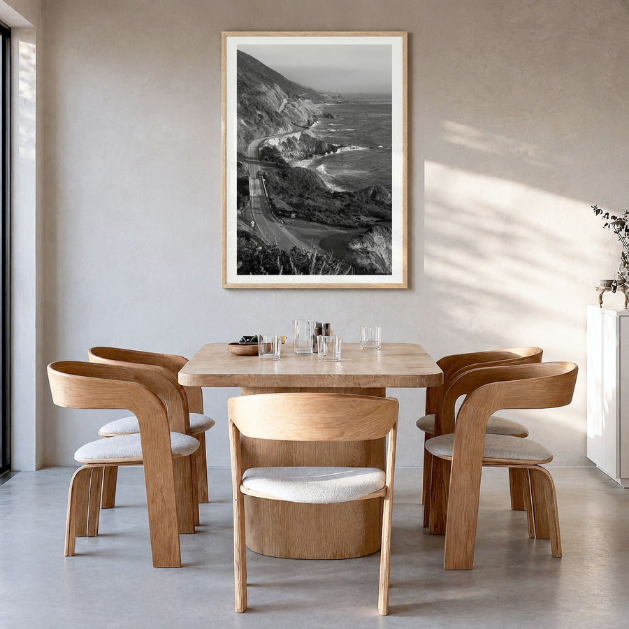 Pacific Coast Highway Photo Poster in a natural wood frame, hanging in a dining room, white border
