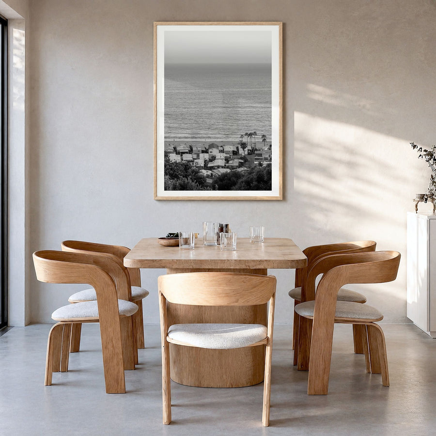 Pacific Palisades Photo Poster in a natural wood frame, hanging in a dining room, white border