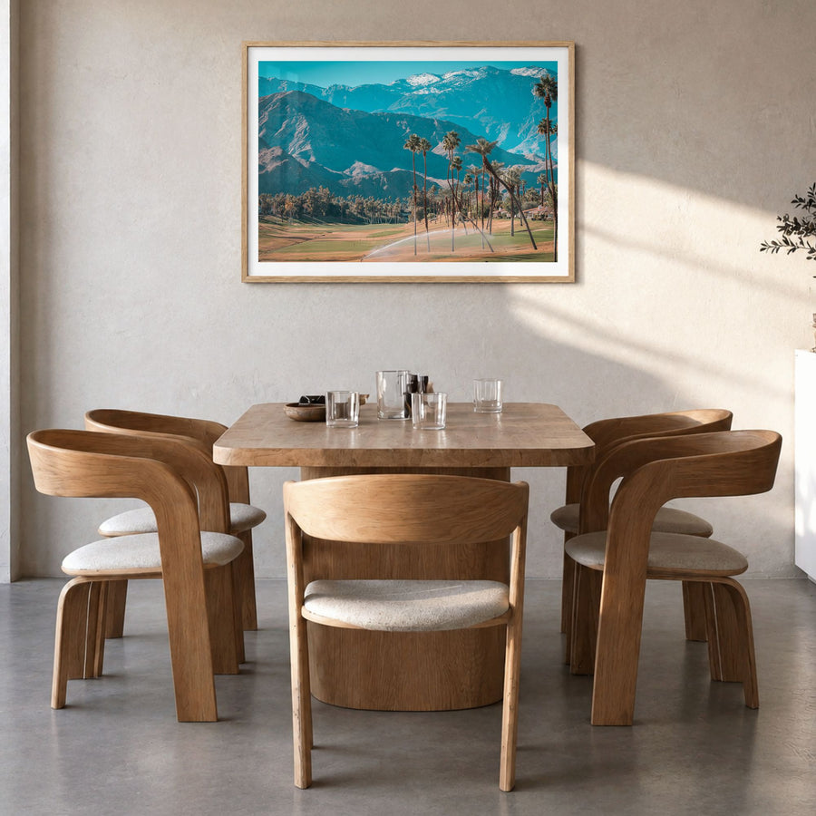 Palm Desert Photo Poster in a natural wood frame, hanging in a dining room, white border