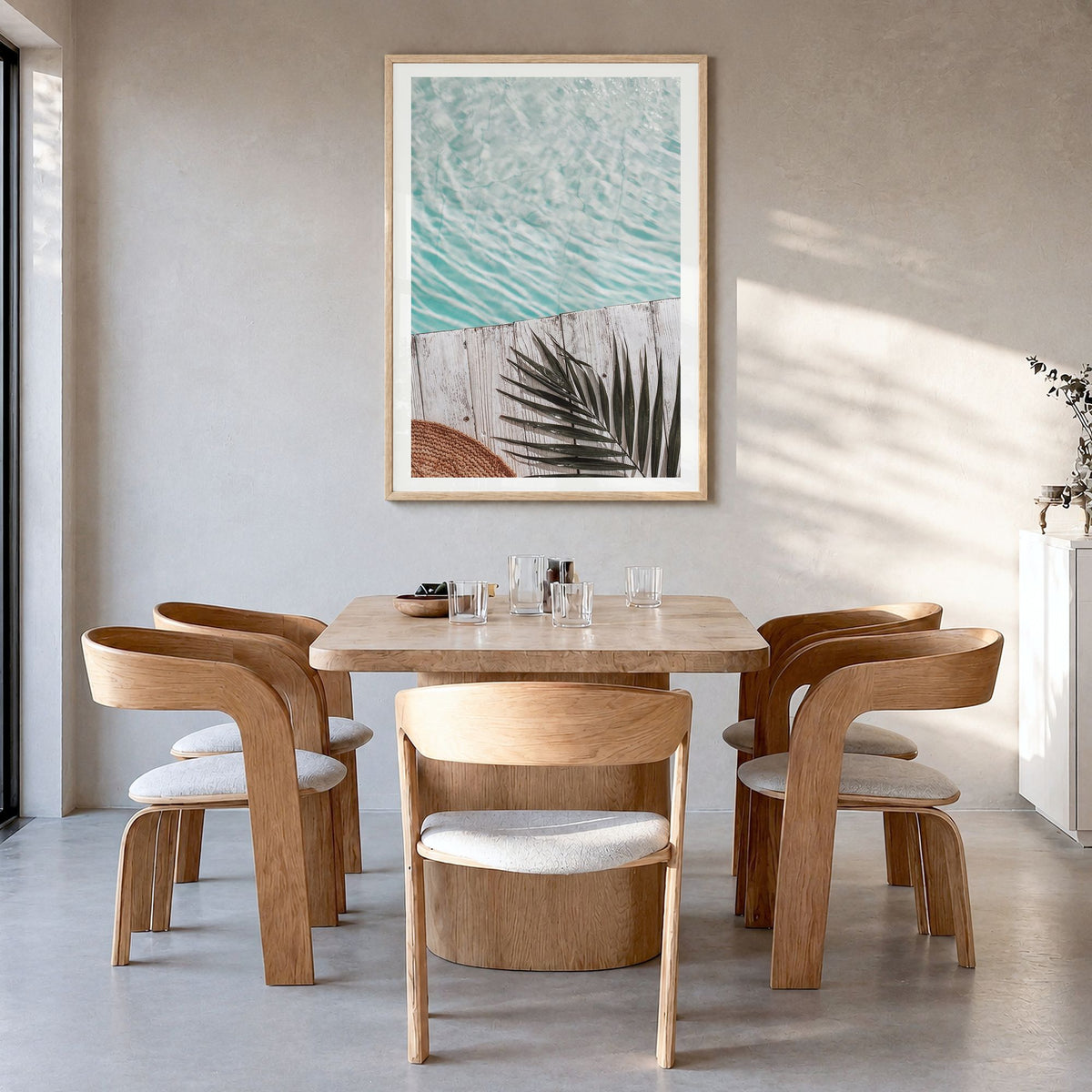 Palm Leaf Pool Photo Poster in a natural wood frame, hanging in a dining room, white border