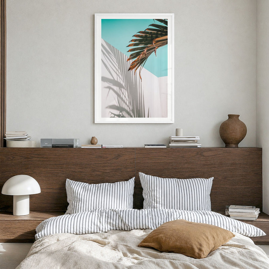 Palm Tree Shadow Photo Poster in a white wood frame, hanging in a bedroom, white border