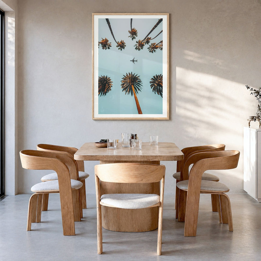 Palm Trees, Sky and Aircraft Photo Poster in a natural wood frame, hanging in a dining room, white border