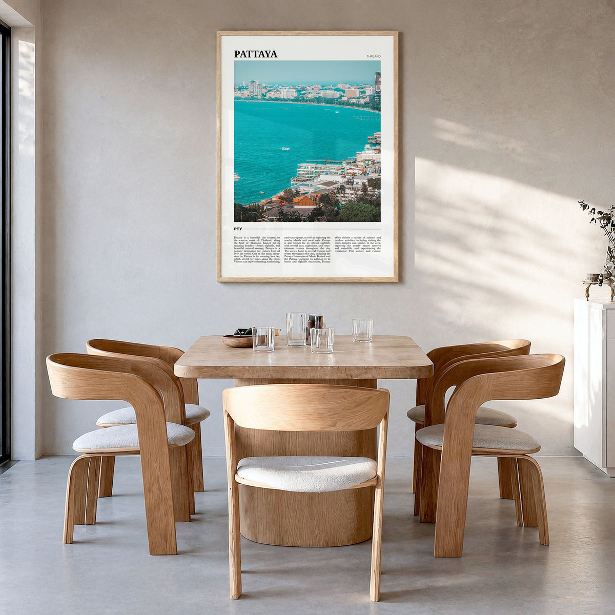 Pattaya Travel Poster in a natural wood frame, hanging in a dining room