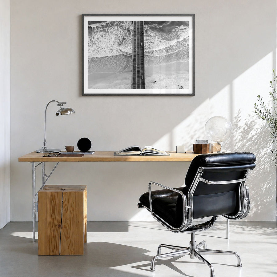 Pensacola Photo Poster in a black wood frame, hanging in a bright home office, white border