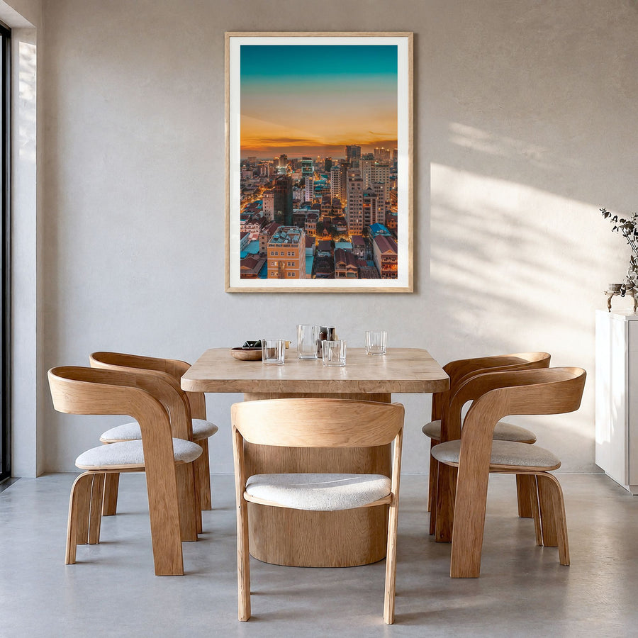 Phnom Penh Photo Poster in a natural wood frame, hanging in a dining room, white border