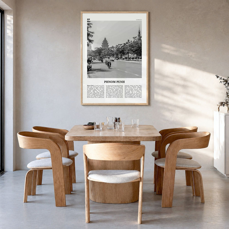 Phnom Penh Newspaper Poster in a natural wood frame, hanging in a dining room