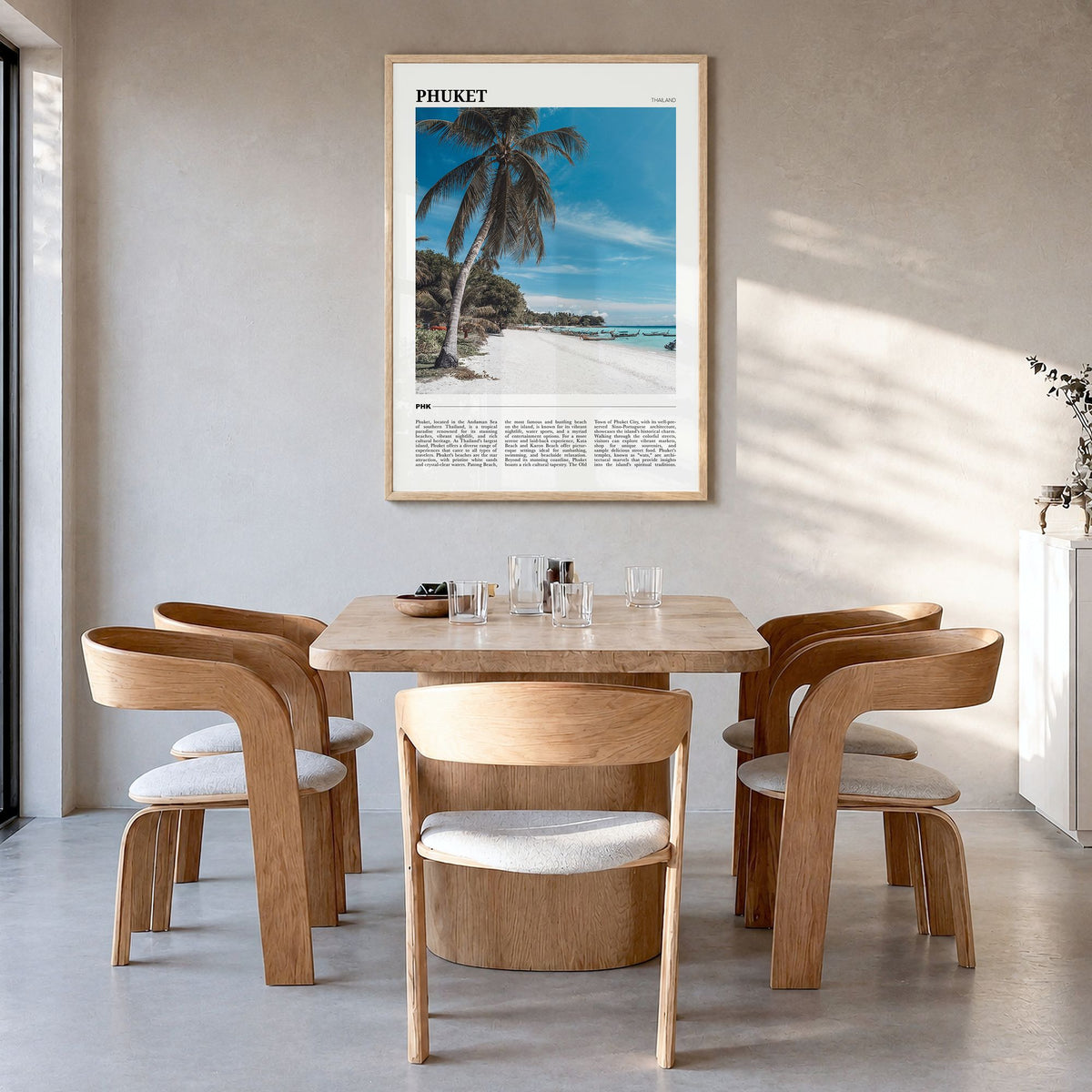 Phuket Travel Poster in a natural wood frame, hanging in a dining room