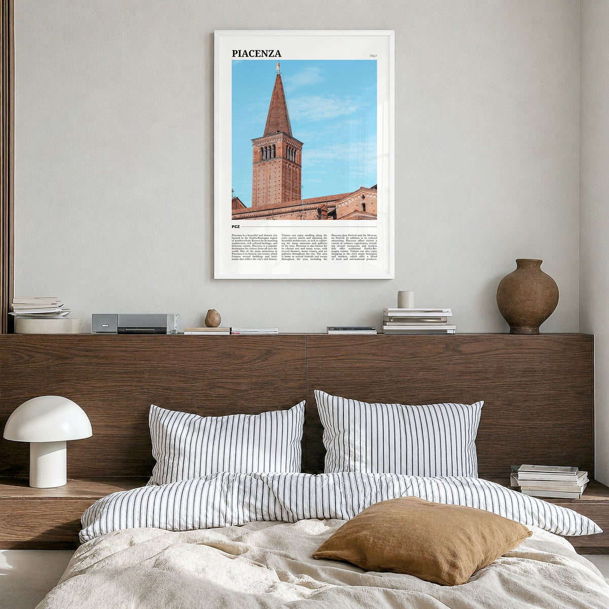 Piacenza Travel Poster in a white wood frame, hanging in a bedroom
