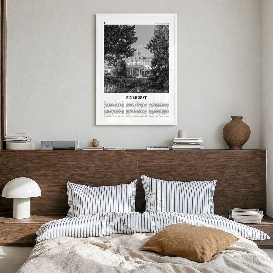 Pinehurst Newspaper Poster in a white wood frame, hanging in a bedroom