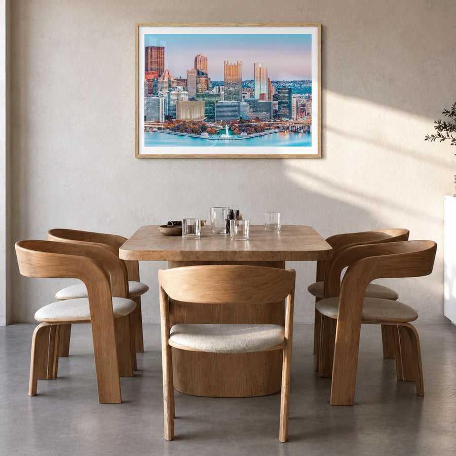 Pittsburgh Photo Poster in a natural wood frame, hanging in a dining room, white border