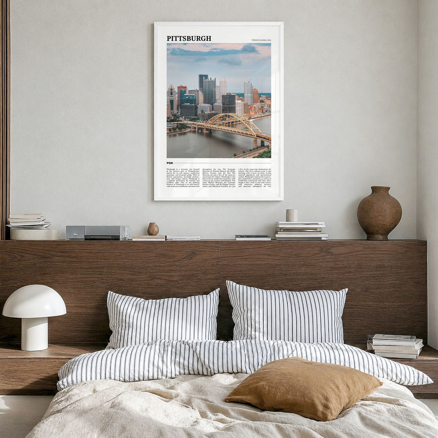 Pittsburgh Travel Poster in a white wood frame, hanging in a bedroom