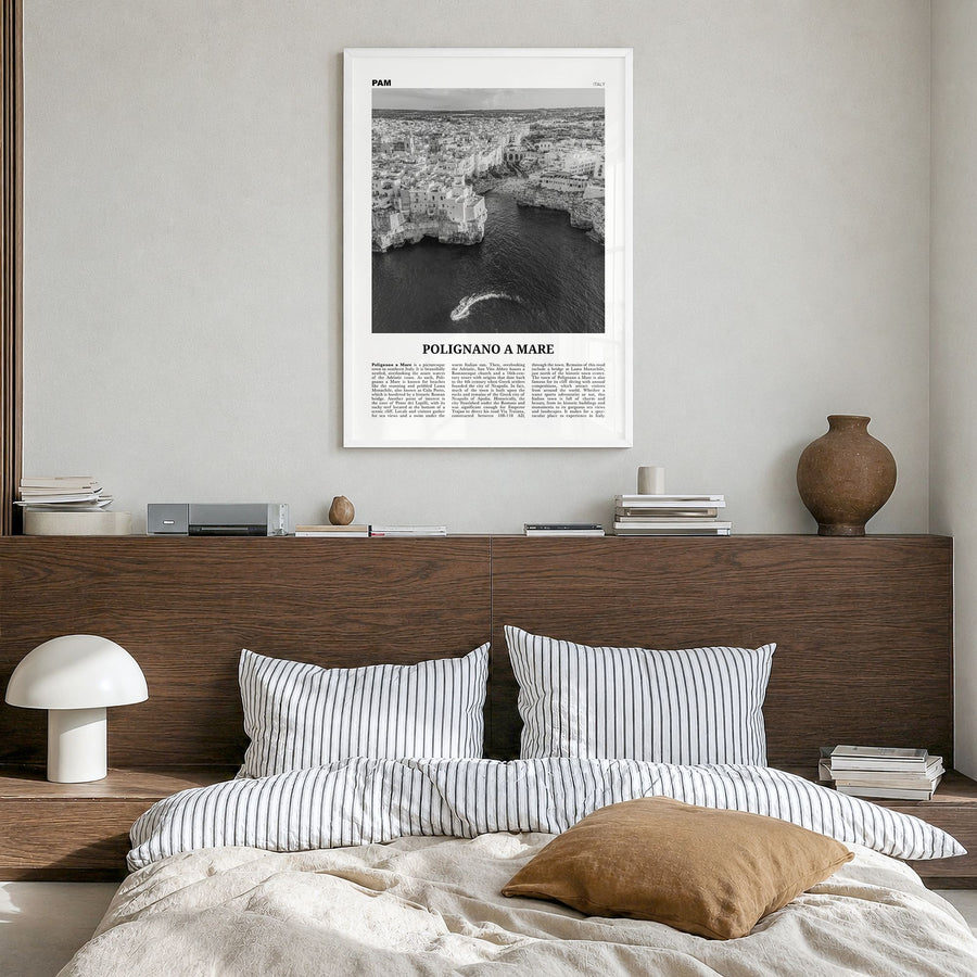 Polignano a Mare Newspaper Poster in a white wood frame, hanging in a bedroom