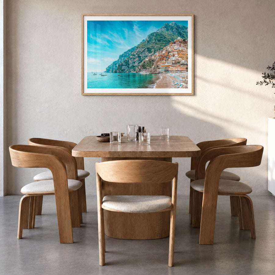Positano Photo Poster in a natural wood frame, hanging in a dining room, white border