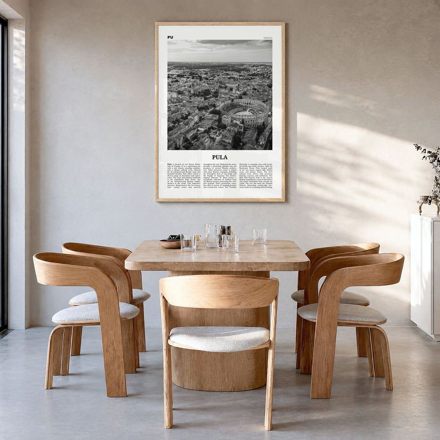 Pula Newspaper Poster in a natural wood frame, hanging in a dining room
