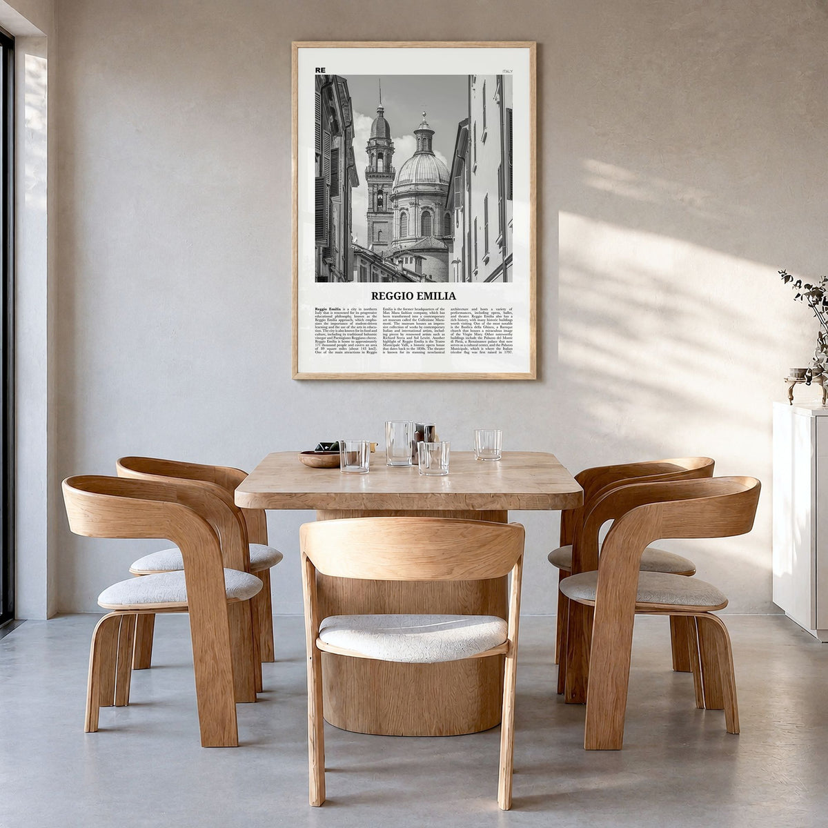 Reggio Emilia Newspaper Poster in a natural wood frame, hanging in a dining room
