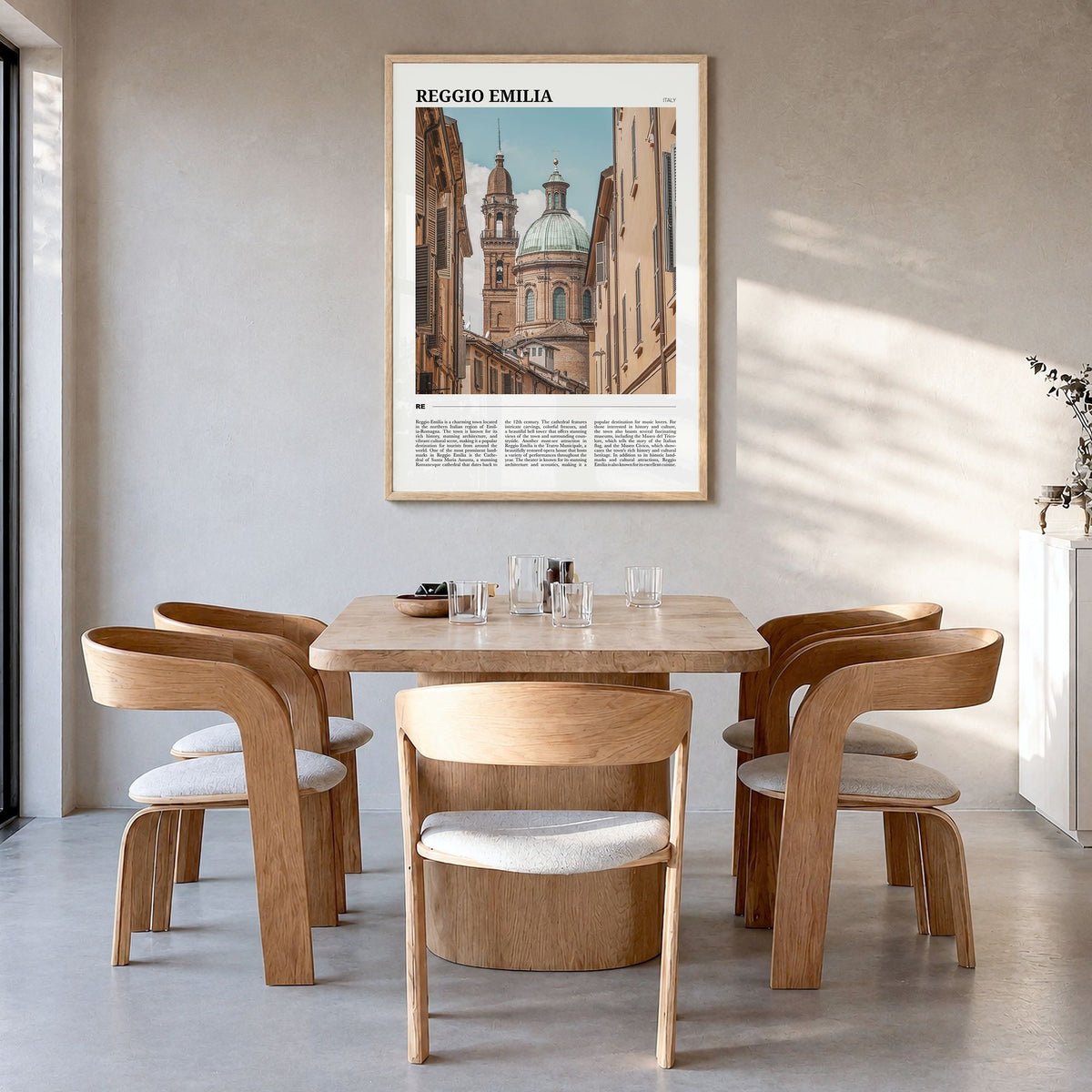 Reggio Emilia Travel Poster in a natural wood frame, hanging in a dining room