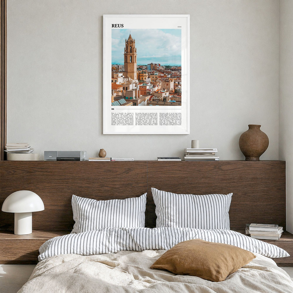 Reus Travel Poster in a white wood frame, hanging in a bedroom