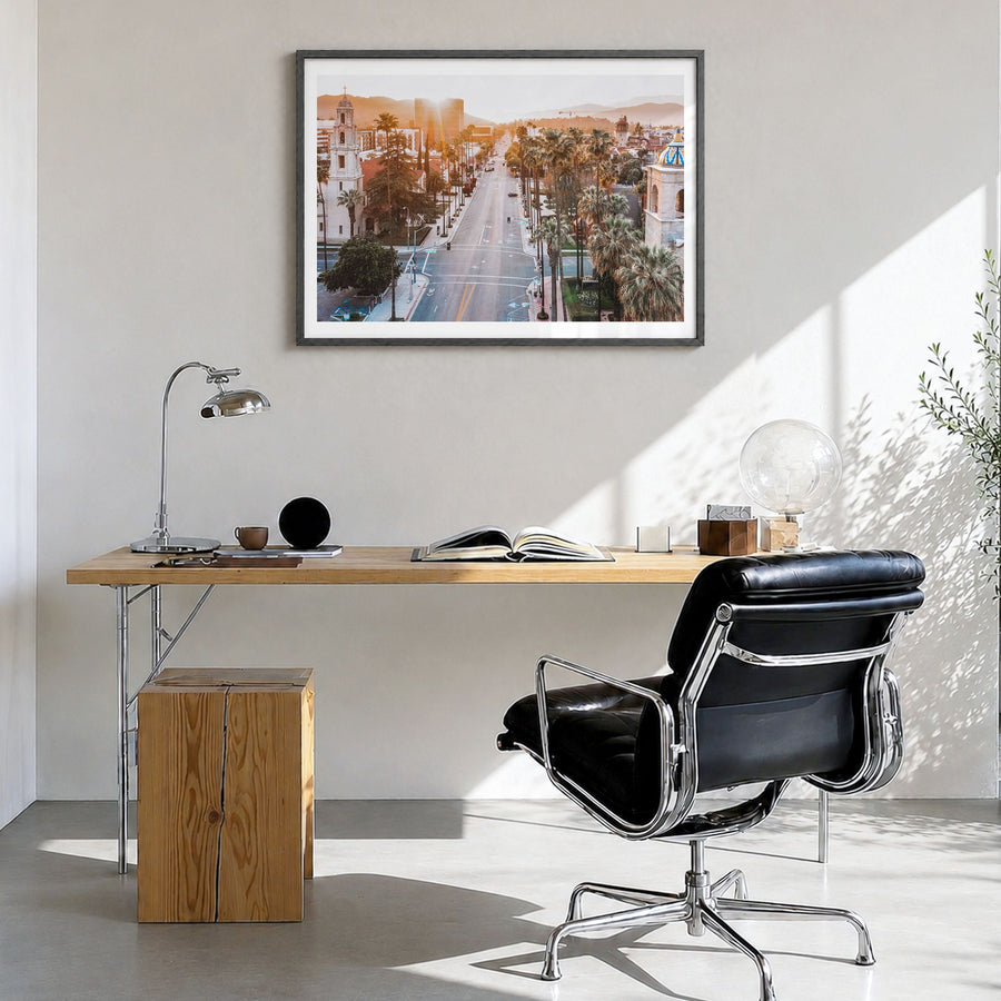 Riverside Photo Poster in a black wood frame, hanging in a bright home office, white border