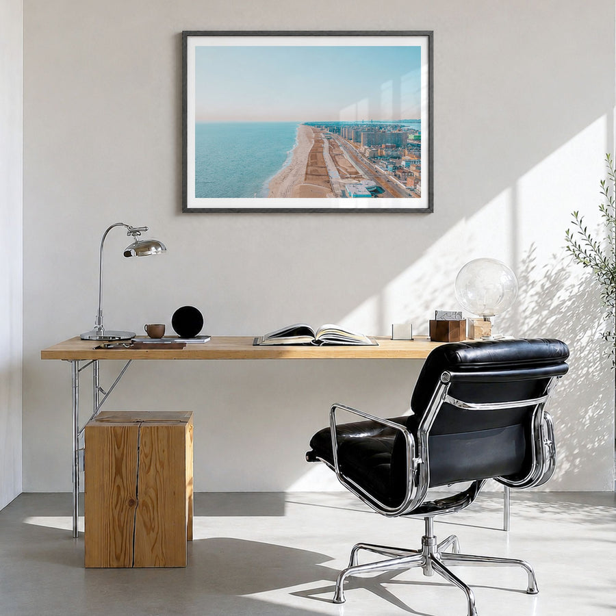 Rockaway Beach Photo Poster in a black wood frame, hanging in a bright home office, white border