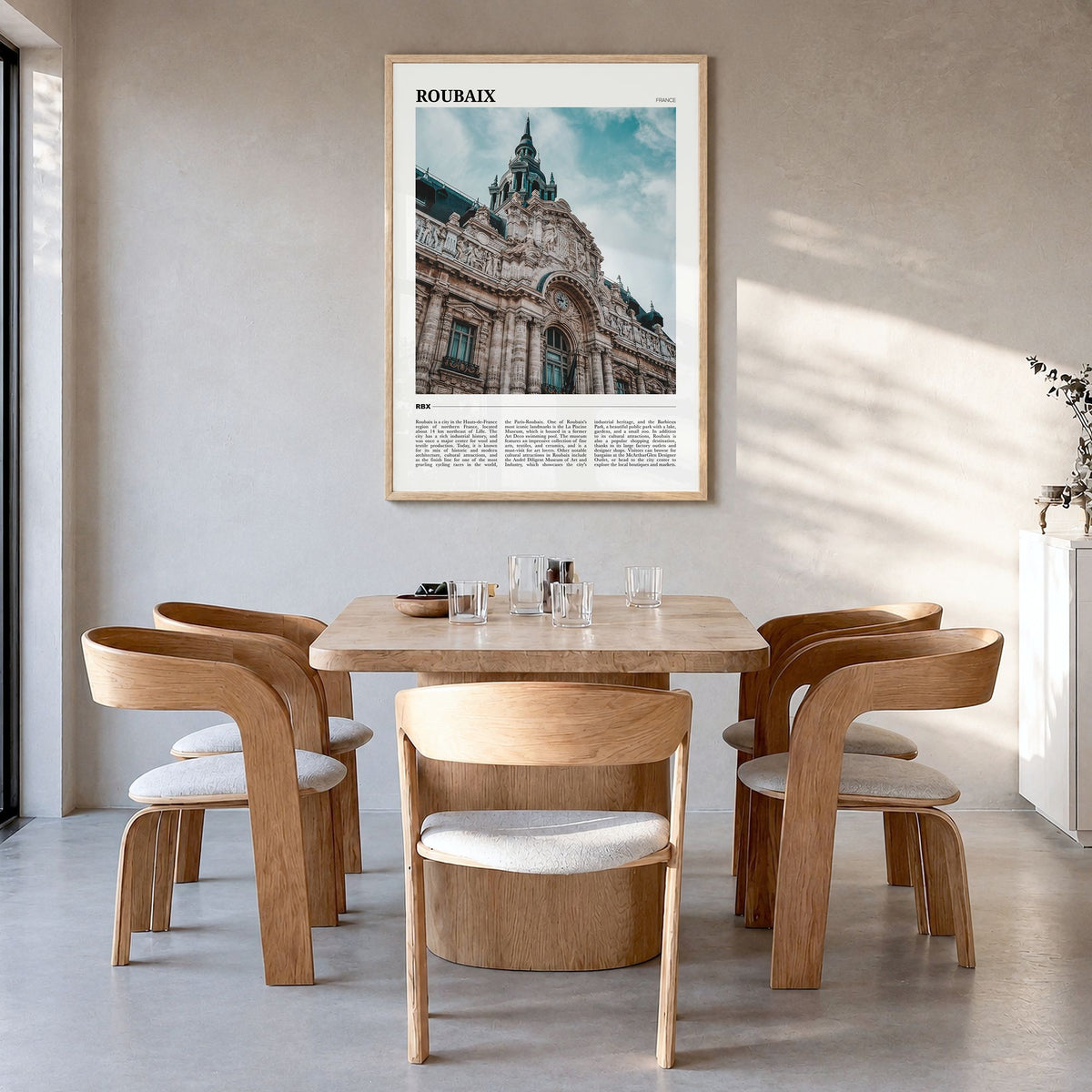 Roubaix Travel Poster in a natural wood frame, hanging in a dining room