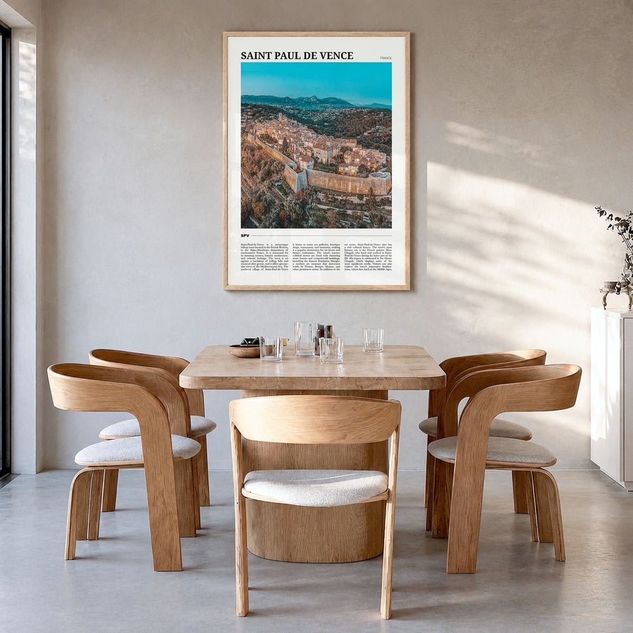 Saint-Paul-de-Vence Travel Poster in a natural wood frame, hanging in a dining room