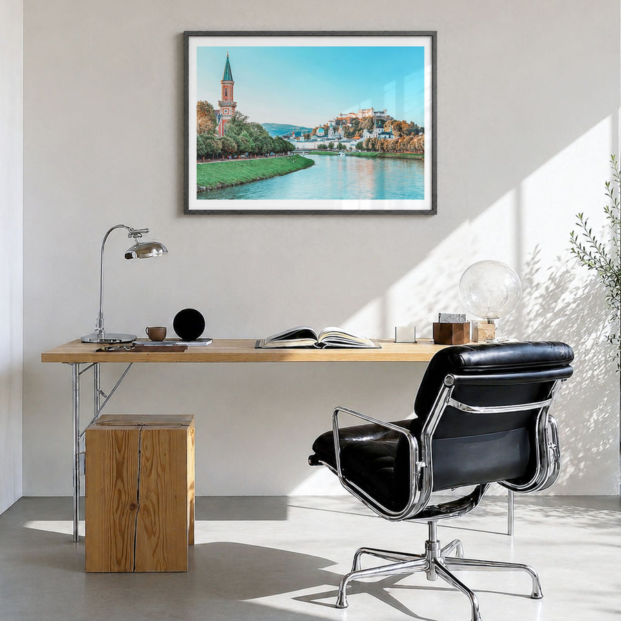 Salzburg Photo Poster in a black wood frame, hanging in a bright home office, white border