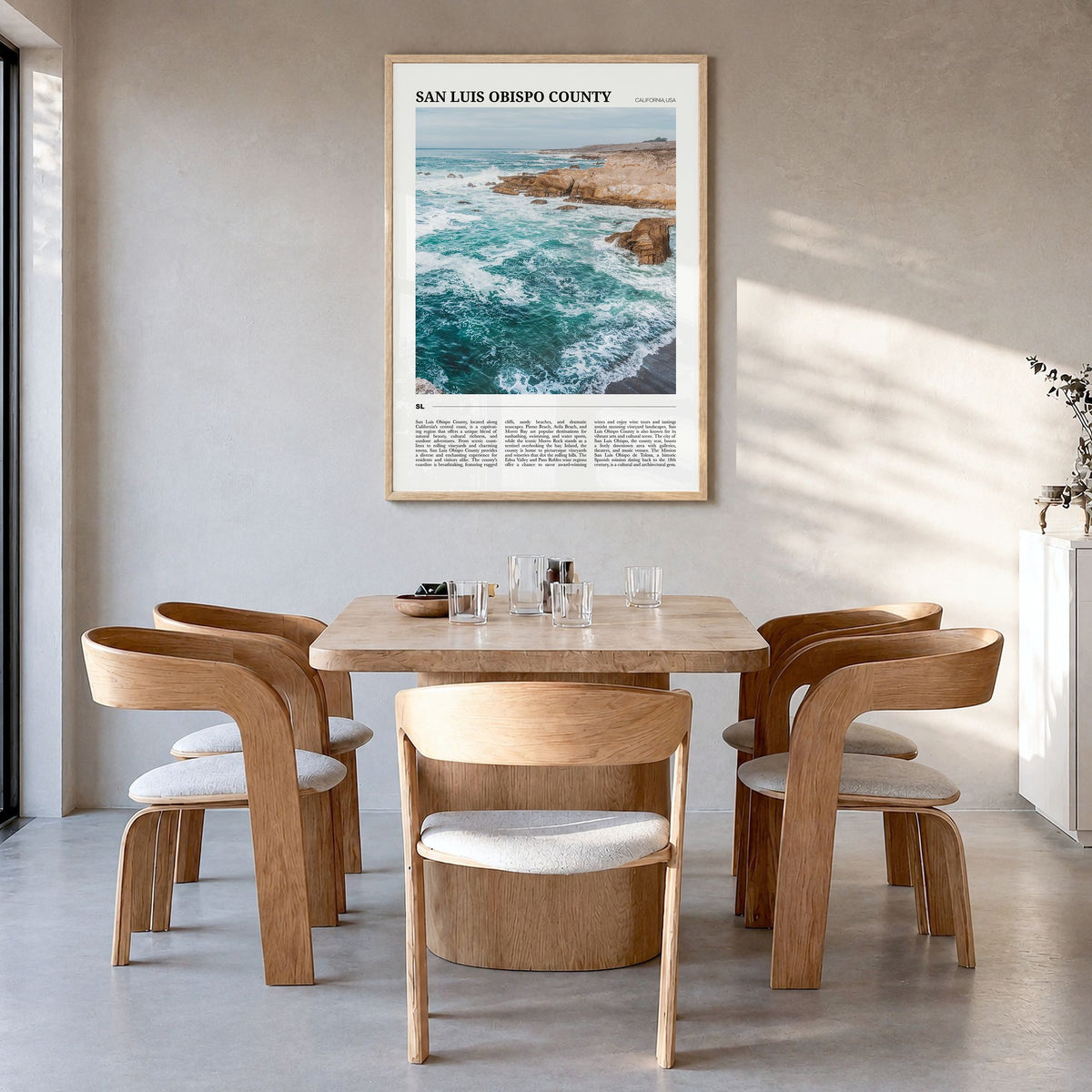 San Luis Obispo County Travel Poster in a natural wood frame, hanging in a dining room
