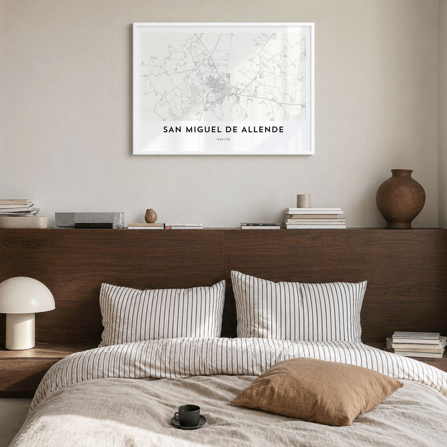San Miguel de Allende Map Poster in a white wood frame, hanging in a bedroom