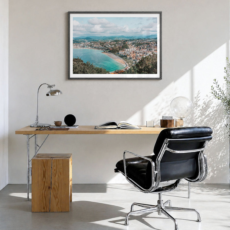 San Sebastián Photo Poster in a black wood frame, hanging in a bright home office, white border