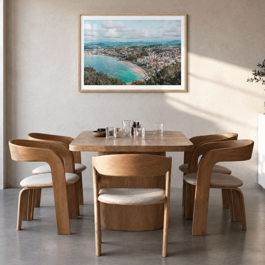San Sebastián Photo Poster in a natural wood frame, hanging in a dining room, white border