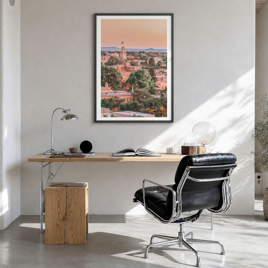 Santa Fe Photo Poster in a black wood frame, hanging in a bright home office, white border