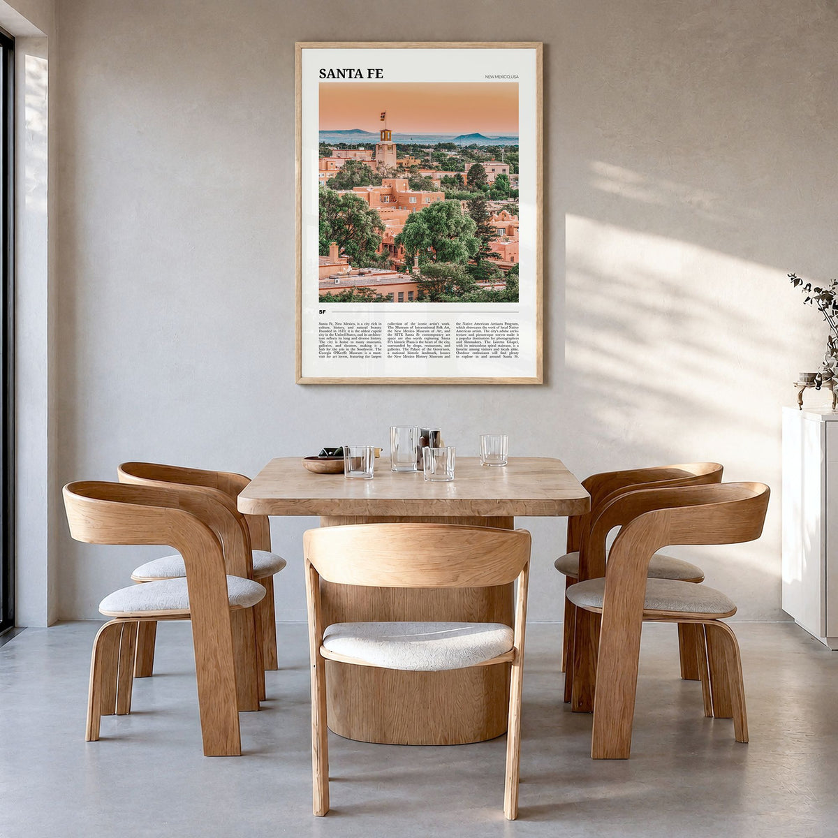 Santa Fe Travel Poster in a natural wood frame, hanging in a dining room