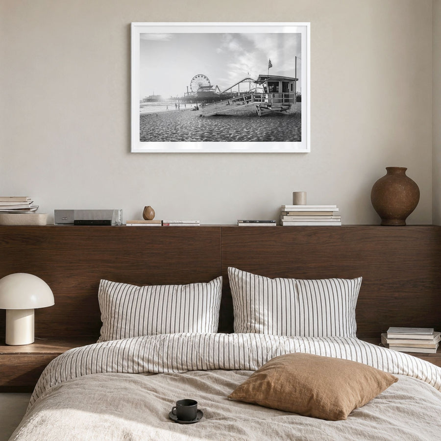 Santa Monica Photo Poster in a white wood frame, hanging in a bedroom, white border